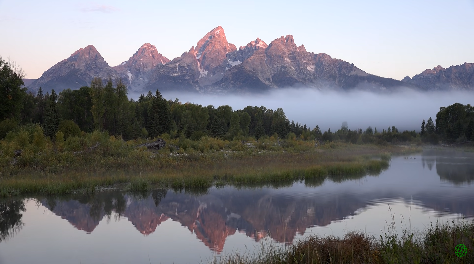 river, fog above the land with trees and bushes, and mountains