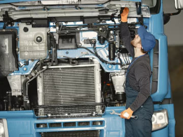 A man looks under the hood of a truck