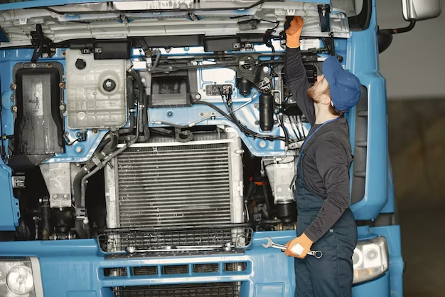 A man looks under the hood of a truck